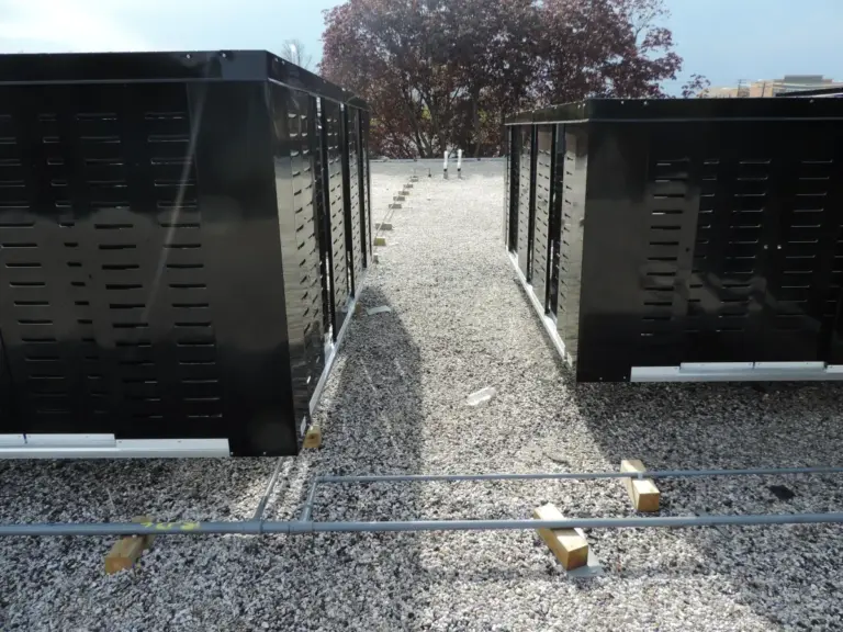 Black louvered metal roof screening systems on a gravel ballasted roof